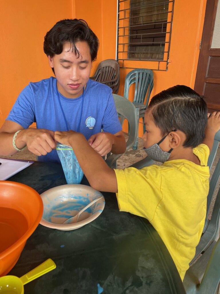 A Therapy Abroad student leads a hands-on fine-motor activity with a child in Belize