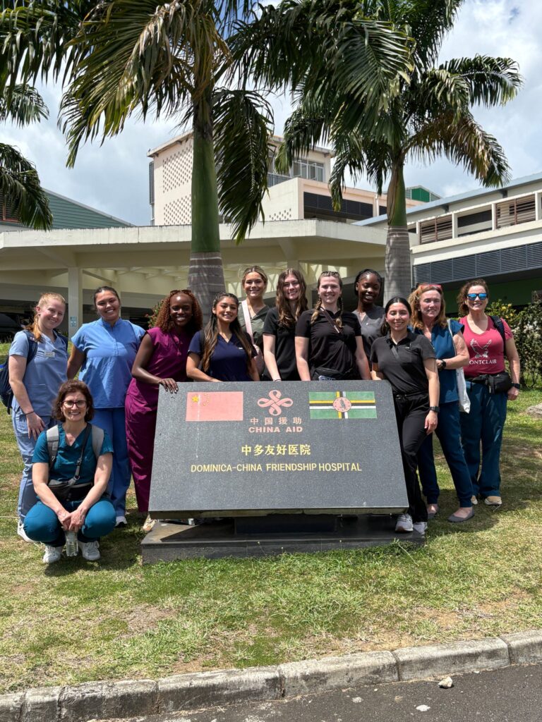 A program group stands outside a hospital in Dominica.
