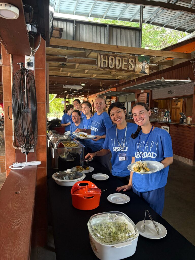 Program participants serve food at a shared buffet.