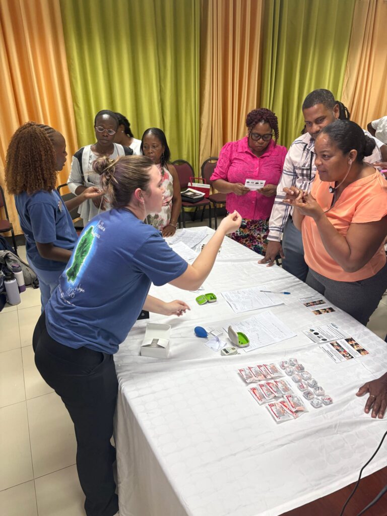 A small group watches a tabletop demonstration.