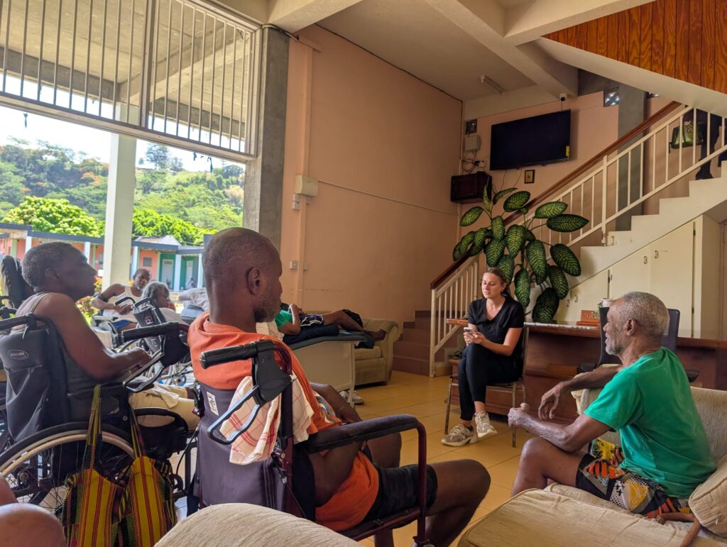 A group of adults takes part in a seated circle activity.