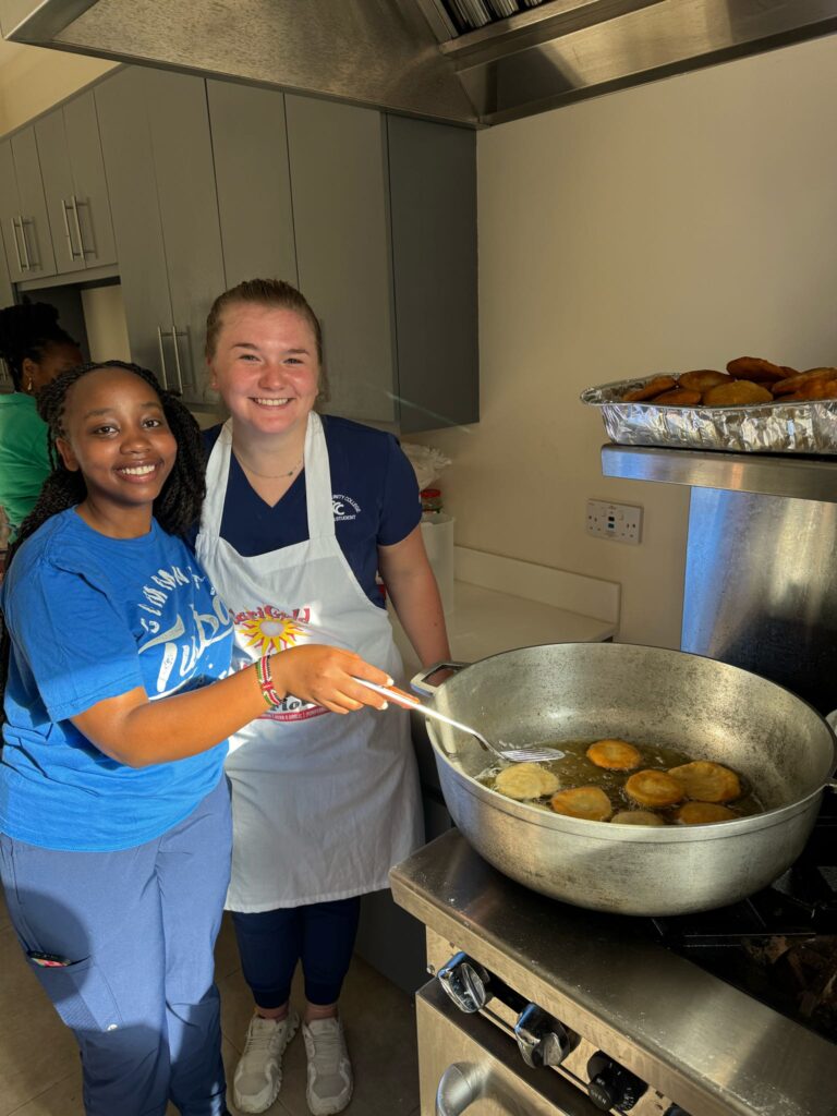 Two participants prepare food at a stove.