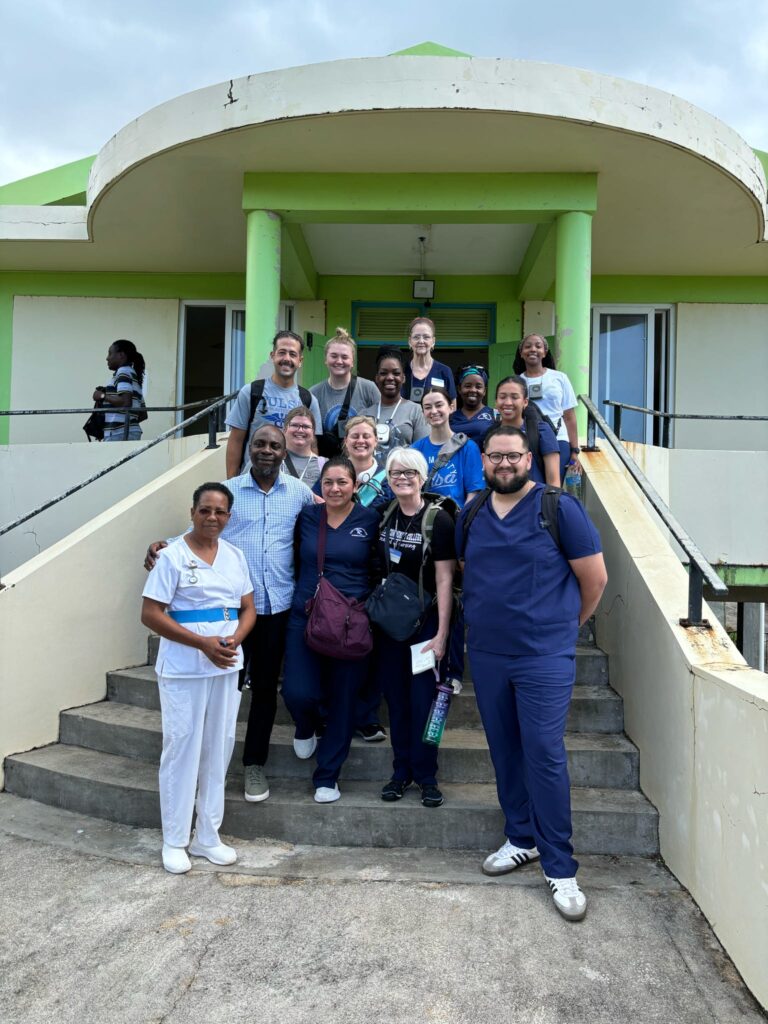 A group gathers on the steps outside a village clinic.
