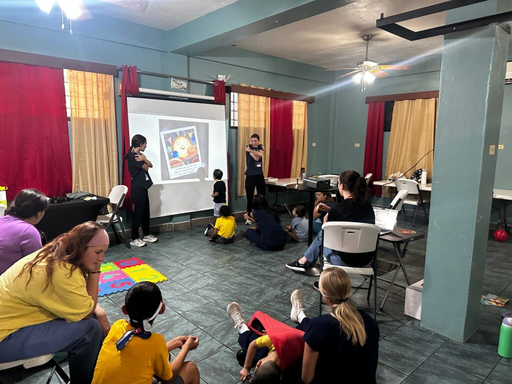 Participants take part in activities on floor mats in a large room.