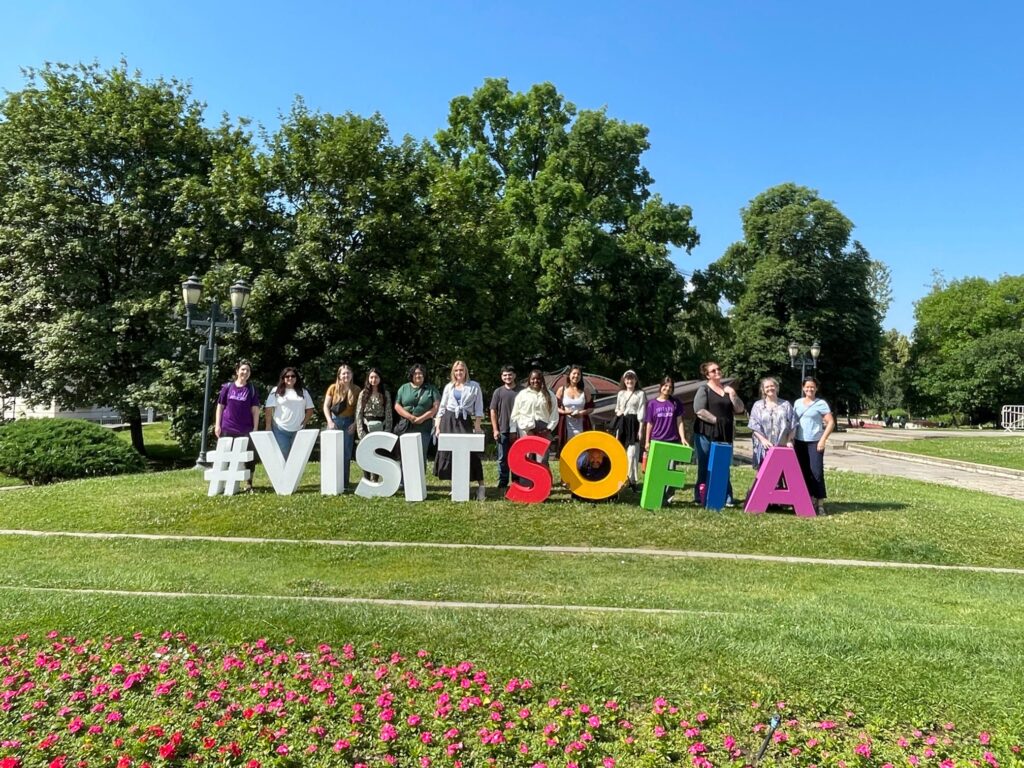 Participants pose beside a Visit Sofia sign.